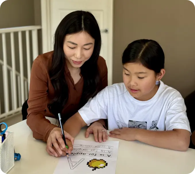 Woman helping a girl writing